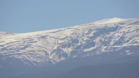 Pan right of snowy mountains