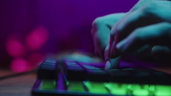 Gamer Typing on Backlight Keyboard Closeup Man Playing Video Game