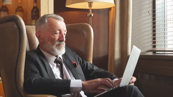 Elderly Businessman in Dark Lighted Room