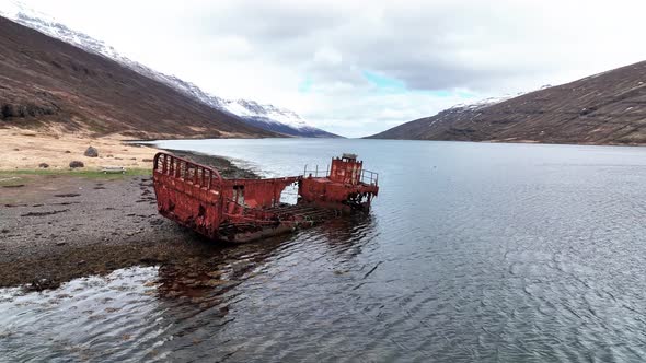 Rusted Shipwreck In Mjoifjordur Fjord In East Iceland - aerial drone shot