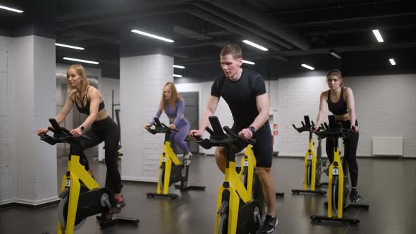 Wellness Group of People is Training on a Spin Bikes Performs Aerobic Endurance Training on the