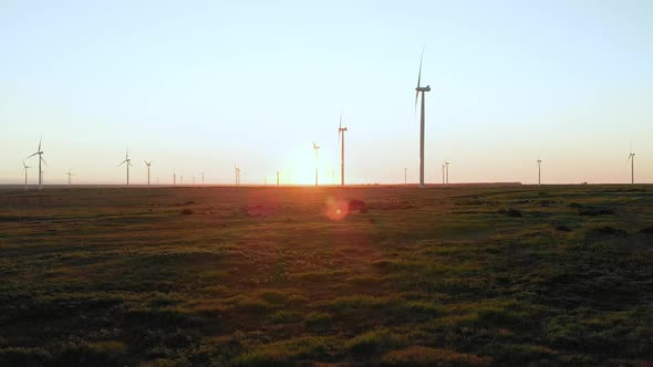 General view of wind turbines in countryside landscape with cloudless sky