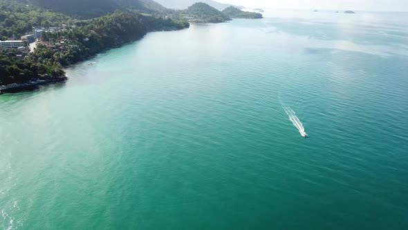 The boat quickly sails on the turquoise sea. Top view from a drone. 