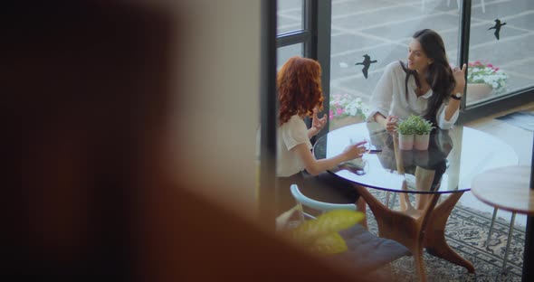 Business women partners drinking tea and talking to each other during a break. Slow motion.