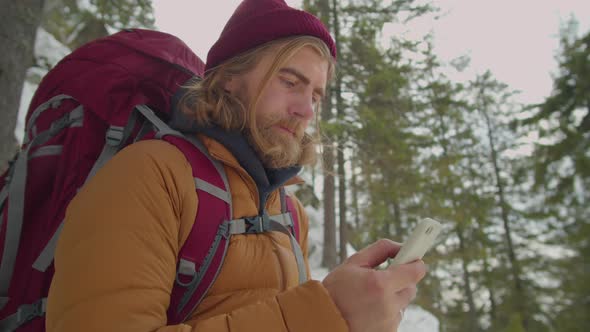 Man Using Smartphone during Winter Hike