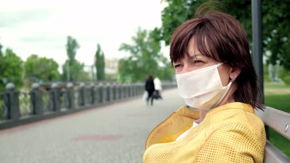 Portrait of Sad Unidentified Woman Posing in Street in Protective White Medical Mask