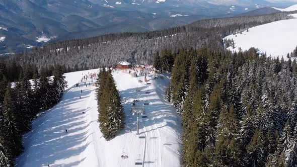 Aerial Ski Slopes with Skiers and Ski Lifts on Ski Resort. Snowy Mountain Forest