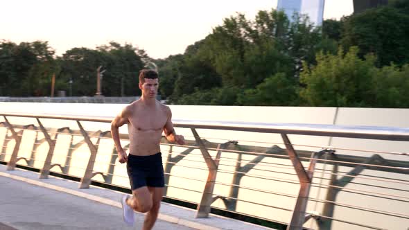 Muscular Athlete Guy Running Outdoor in the Morning Jogging