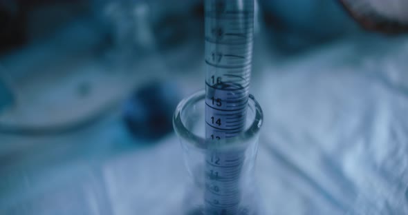 Tracking close up shot of purple liquid being taken out from a conical flask.