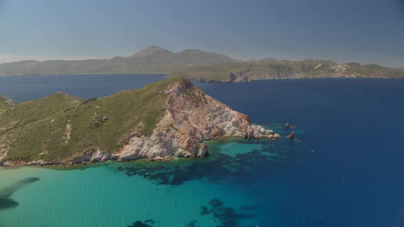 Forward Aerial Pan of Cliffs Cascading into the Aegean Blue Sea in Milos