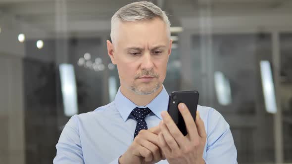 Grey Hair Businessman Using Smartphone Typing Message