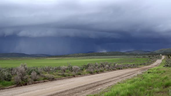 Time lapse looking down dirt road into dark shelf cloud storm moving