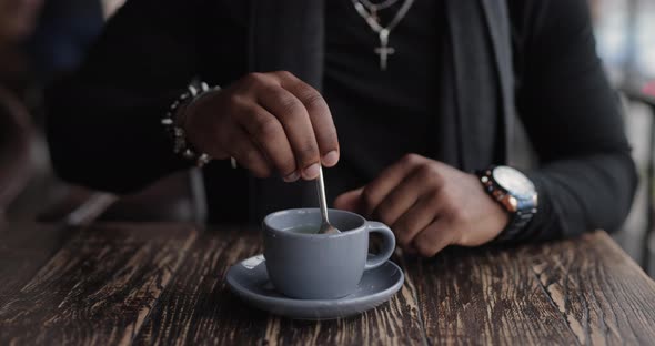 African American Man Mixing Sugar in a Tea Cup