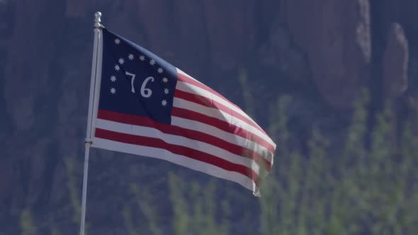 American 76 flag wide shot against mountains slow motion