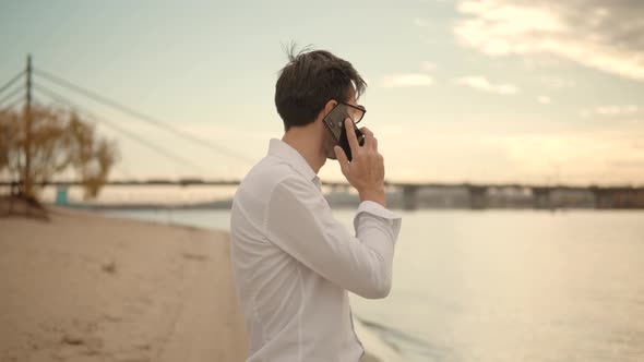 Businessman Talking Smartphone On Sea.Freelancer Remote Working On Mobile Phone Call To Colleagues