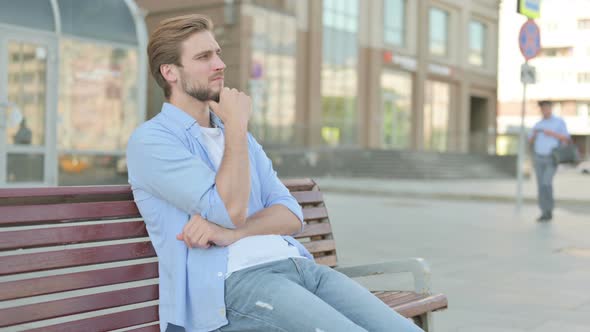 Pensive Man Thinking While Sitting Outdoor on Bench