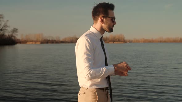 Man Relaxing And Using Wireless Headphones And Listening Music From Smartphone On Nature.