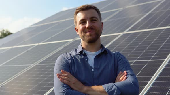 Happy Caucasian Engineer in Helmet Smiling at Camera at Solar Power Station Outside