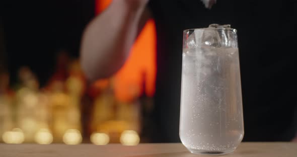 Bartender Adds Ice Cubes to the Glass with Refreshment Beverage in Slow Motion Making the Limonade