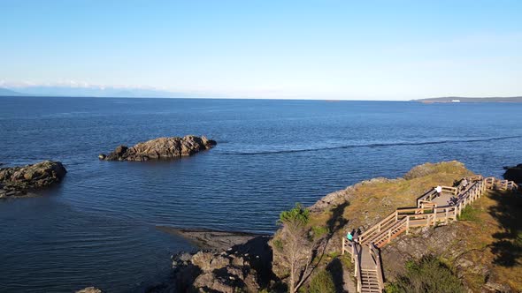 Aerial view of Neck Point Park in Nanaimo. Drone flying above quickly in a curve above people, bluff