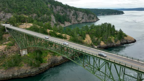 Wide static aerial view of cars commuting over the Deception Pass bridge.