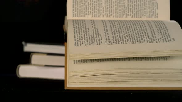 Old book falling on black background, Slow Motion alt