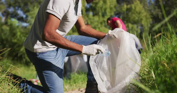 African American man looking and smiling at camera during river clean-up day