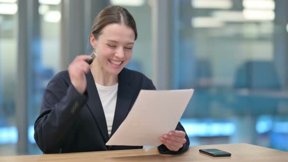 Young Businesswoman Celebrating Success on Documents