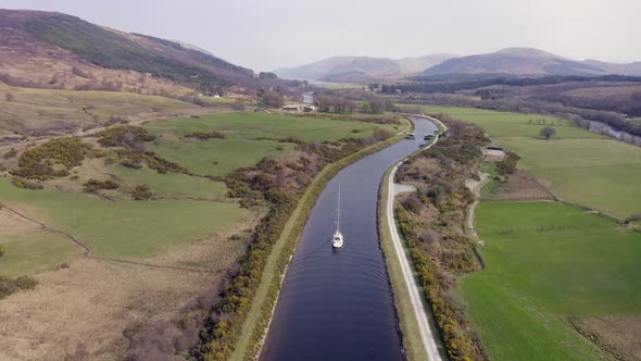 A Luxury Sailing Yacht Motoring Along a Canal with Beautiful Landscape