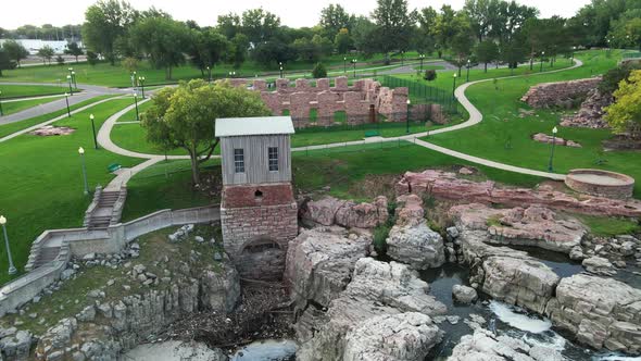 Flying over Falls Park in South Dakota showing preserved pieces of old mill stone walls.
