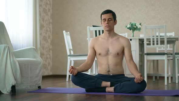 Man Sitting on the Floor and Meditates