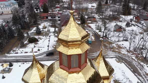 Aerial View of Ukrainian Church with Golden Domes in Carpathian Village in Winter alt