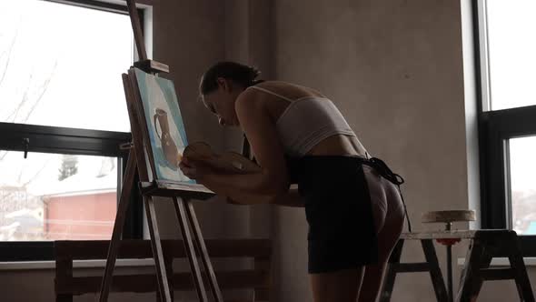 Woman Painting on Easel in Workshop