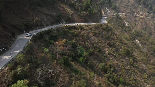 drone follow a car driving on narrowed Himalayan road in india Himachal Pradesh mountains region tre