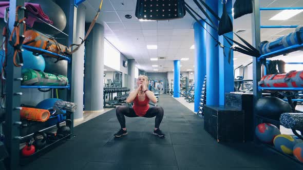 Sporty woman exercising in gym. Fit female doing intense training workout in gym