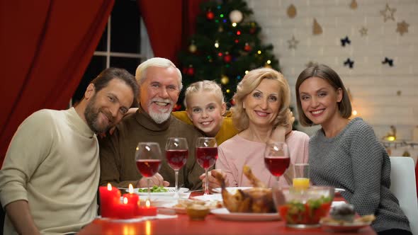 Family Sitting at Table Having Traditional Xmas Dinner Looking to Camera Zoom-In