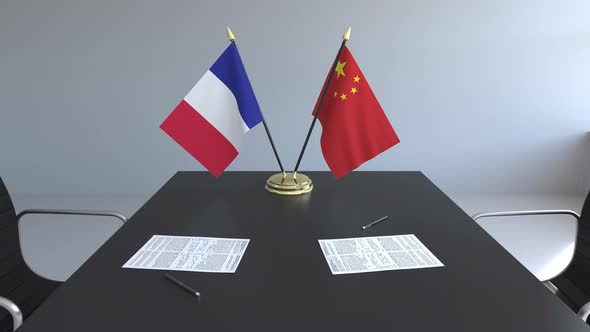 Flags of France and China and Papers on the Table