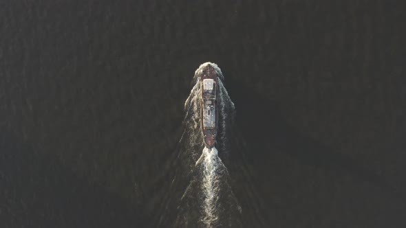 Aerial Shot of Cargo Ship Floats on the River or Sea. Freight Boat Carriage Goods. Drone Fly Over