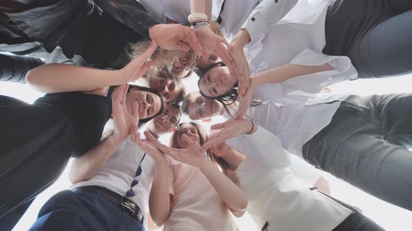 A Group of High School Students Look Through the Shape of a Circle Created From Their Palms