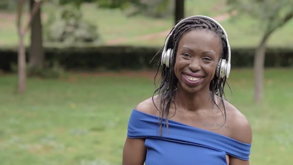 Beautiful young black american woman with headphones making selfie in the park