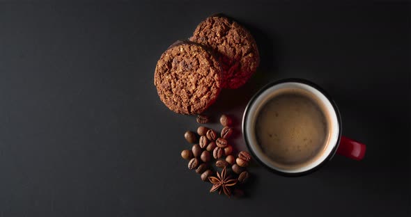 Cinemagrah, chocolate cookies and cup of hot coffee on black 