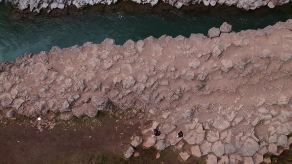 Aerial Shot of Rocky Formations and Strong River Flowing Studlagil Canyon