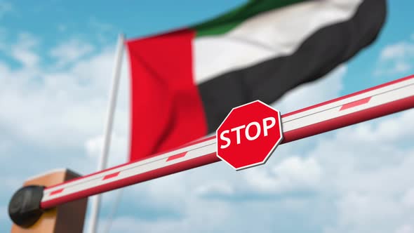 Opening Boom Barrier with Stop Sign Against the UAE Flag