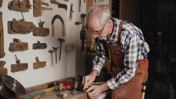 Carpenter Sharpening a Chisel