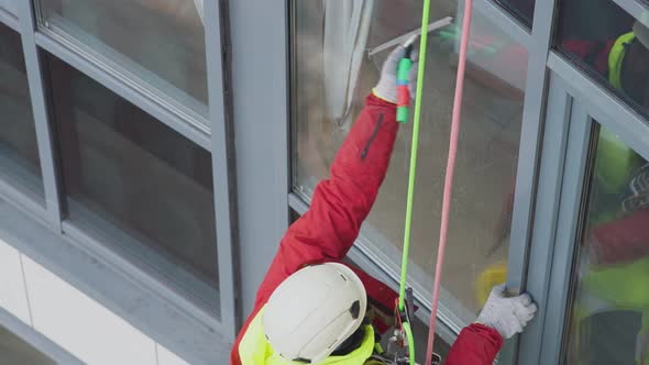 Industrial Climber Washes Windows Hanging on Safety Ropes