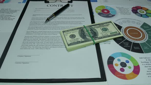 Business Contract And Dollars On The Table In The Office Of The Company