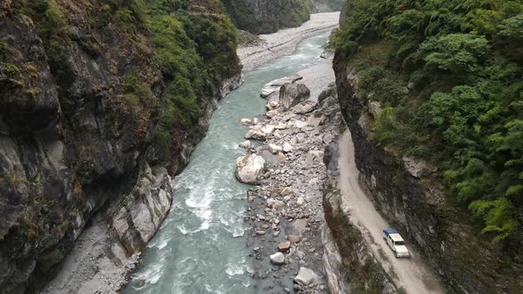 Flying down to the Marsyangdi River as vehicle drives on dirt road