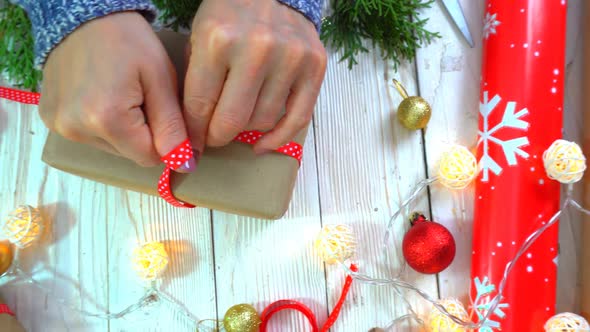 Woman is Wrapping Christmas Presents on the Table Concept of Preparing for the New Year and