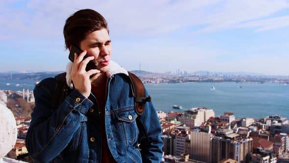 A Young Man Stands on Top of Istanbul and Talking with Somebody on His Phone