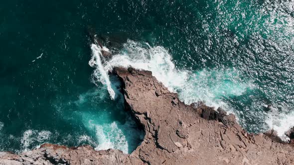 Turquoise Blue Waves Of Mediterranean Sea Splashing On The Rocky Cliffs In Summer At Cala Figuera At